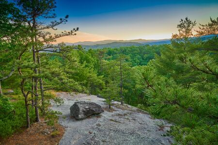 Exposed rock face with large boulder at sunset.の写真素材