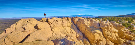 Woman standing on top of sandstone formations at El Malpais National Monument, New Mexico.の写真素材