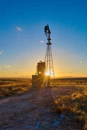 Water pump Windmill at sunset, City of Rocks State Park, NM.の写真素材