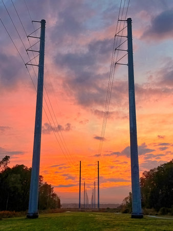 Transmission lines at dusk with colorful clouds.