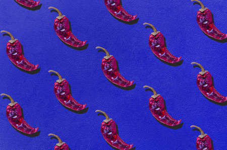 Dry red chili peppers on azure blue texture background. Flat lay. Minimal organic vegetable concept.の写真素材