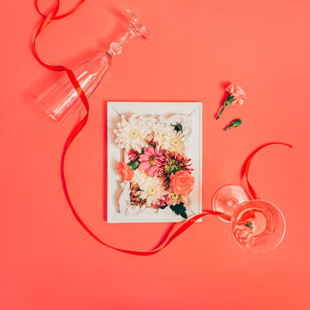 Creative composition of various flowers, champagne glasses, and renaissance frames. Elegant red...