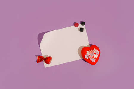 Creative layout made of fruity sweets and red heart with little pastel flowers. Flat lay love concept. Valentine's greeting card. Light pastel background with a paper note. Trendy Decorative Design.の写真素材