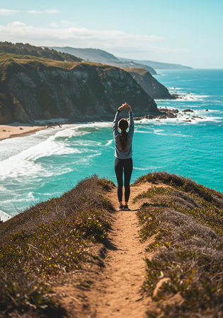 Woman standing on top of a cliff and looking at the ocean.の素材