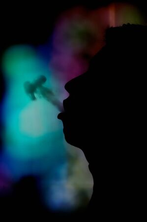 Photo of smoking man's profile with back lightingの写真素材