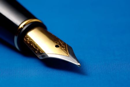 Photo of golden fountain pen on the blue backgroundの写真素材