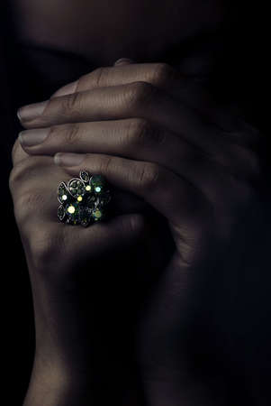 Studio portrait of model's hands with jewel ring in dramatic lightの写真素材