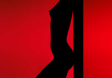Dancing silhouette of  woman in back-light on a red backgroundの写真素材