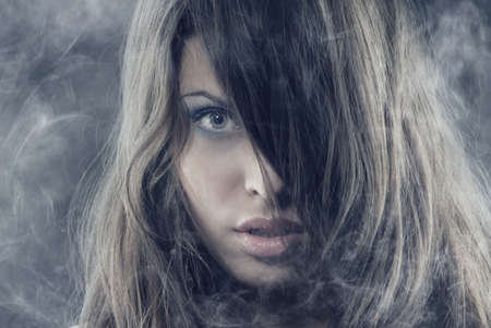 Sexy woman with long hairs in the heavy smokeの写真素材