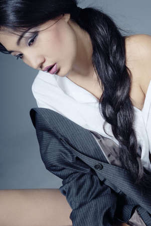 Sad Asian lady with long hairs sitting in the studioの写真素材