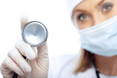 Close-up photo of the stethoscope and blurred docror in maskの写真素材