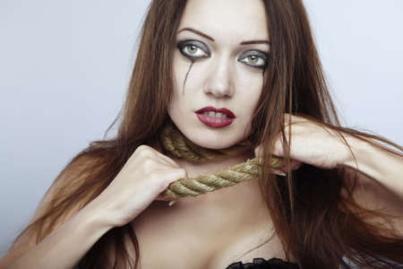 Gothic lady with depressive makeup trying to tear the slipknotの写真素材