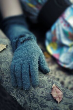 Close-up photo of the woman hand in woolen glove outdoors during cold autumn. Shallow depth of fieldの写真素材