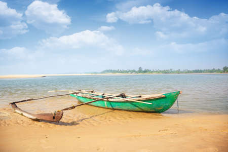 Old small boat at the tropical beach in India. Vibrant colorsの写真素材