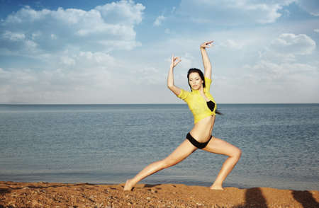 Elegant lady outdoors making yogi exercise at the summer beach. Special colorsの写真素材