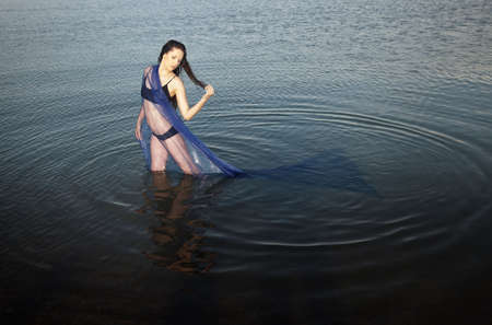 Sensual lady in bikini standing in the water.の写真素材