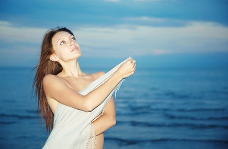 Young beautiful lady enjoying the fresh breez from the night seaの写真素材