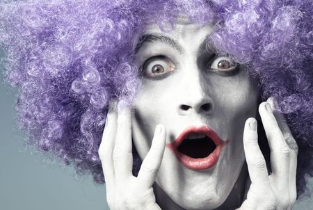 Clown with artistic makeup and wig expressing surprise. Natural light and colorsの写真素材