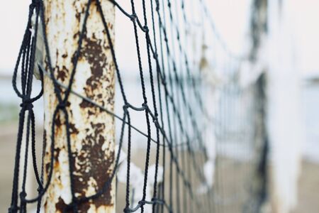 Old net attached to the poles at the beach. Shallow depth of field added for more natural viewの写真素材