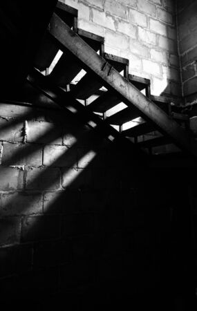 Metal old staircase in the abandoned building. Natural light and shadowsの写真素材