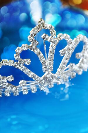 Close-up photo of the silver diadem with diamonds on a blue background with bokeh. Shallow depth of field added by macro lens for natural viewの写真素材