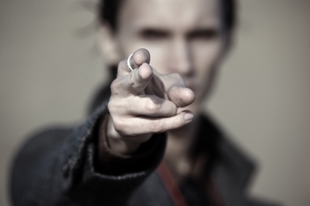 Close-up photo of the criminal man pointing finger. Focus on the fingertipの写真素材