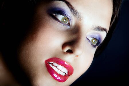 Beautiful lady with perfect dramatic makeup on a dark backgroundの写真素材