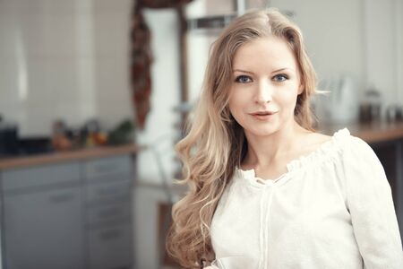 Blond lady indoors at her kitchenの写真素材