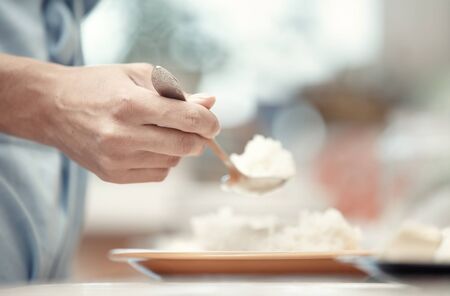 Woman hand holding spoon with rice-milkの写真素材