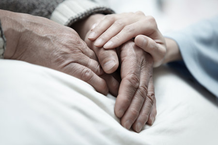 Hand of woman touching senior man in clinicの写真素材