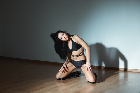 Woman in lingerie sitting in the dark ball roomの写真素材