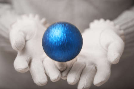 Human hands in warm mittens throwing Christmas ball