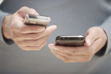 Human hands using two smartphones for data transfer