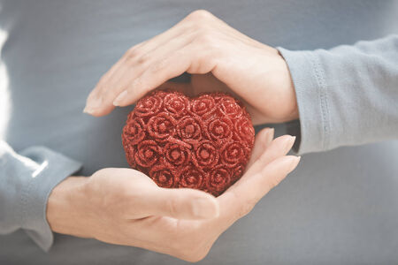 Hands of woman holding red heart. Close-up viewの写真素材