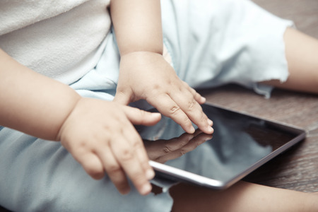 Baby with tablet computer. Close-up photo of the handsの写真素材