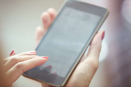 Hands of woman using smartphone