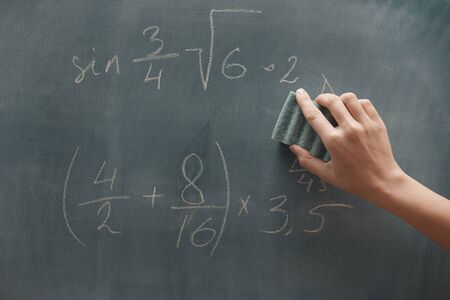 Hand of student studying mathematics and writing on a blackbroardの写真素材