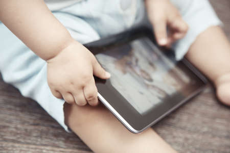Baby with tablet computer. Close-up photo of the handsの写真素材