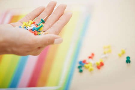 Woman hand with colorful pushpinsの写真素材