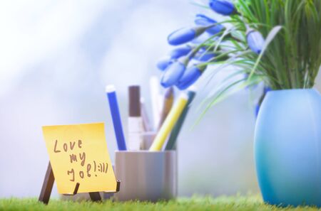 Adhesive note with Love my job text at green office