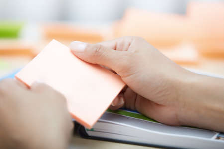 Hands holding sticky note with empty space