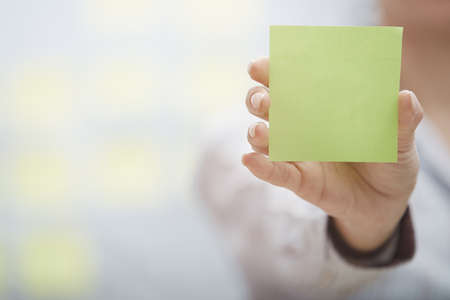 Woman holding sticky note with empty space