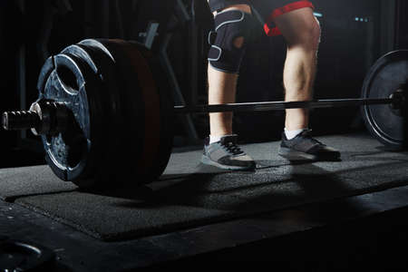 Man at the heavy barbell in fitness club. Close-up viewの写真素材