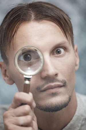 Man with magnifying glass. Vertical portraitの写真素材