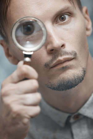 Man with magnifying glass. Vertical portraitの写真素材