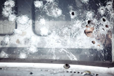 Man behind broken glass of the carの写真素材