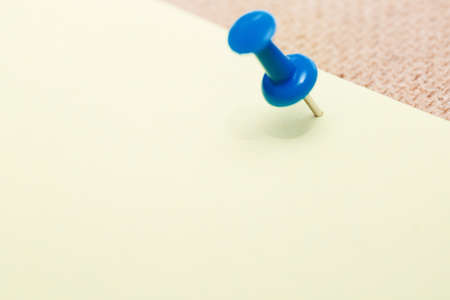 Adhesive note and blue pushpin. Close-up viewの写真素材
