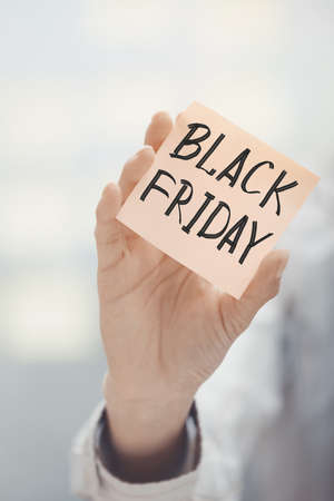 Woman holding sticky note Black Friday textの写真素材
