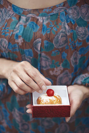 Woman holding Christmas eclair at homeの写真素材