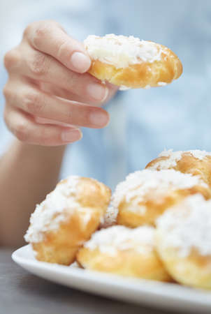 Woman eating eclairs at home. Vertical photos